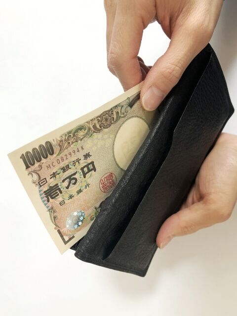 財布から一万円を出す男の手