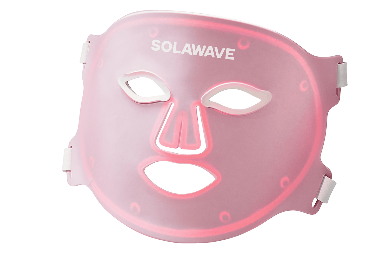눈, 코, 입 부분에 컷아웃이 있고 흰색 고무줄이 있는 핑크색 Solawave LED 광선 치료 마스크입니다.