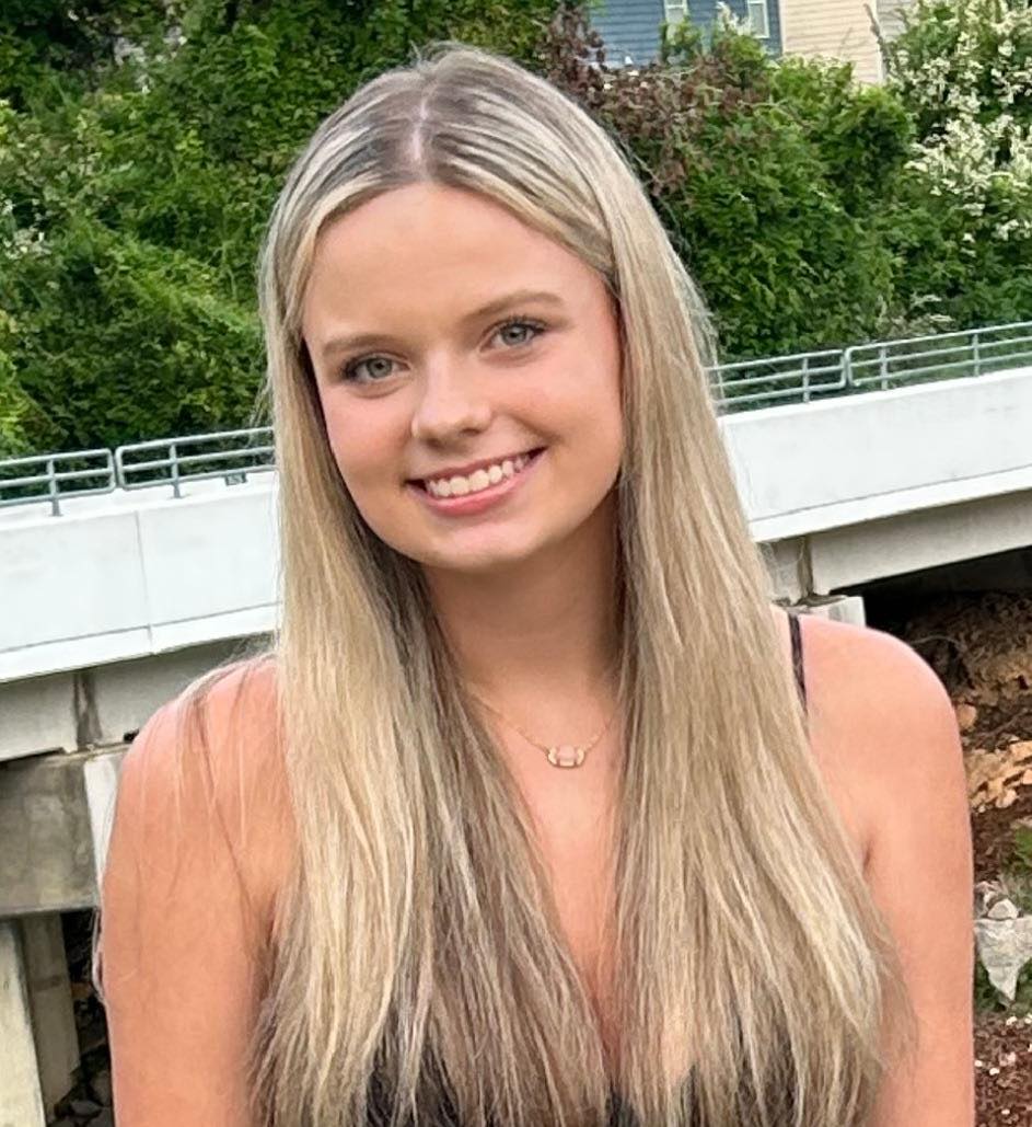 파란 눈을 가진 금발의 십대 매켄지 달튼이 웃고 있다.