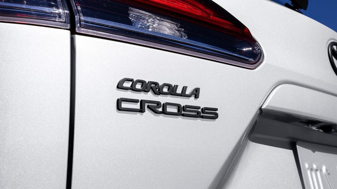 白い 2025 トヨタ カローラ クロス ハイブリッド XSE のトランクリッドのバッジのクローズ アップ ショット。