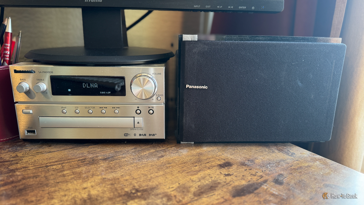 机の上にあるパナソニック SA-PMX9DB マイクロ Hi-Fi システムとその隣にスピーカーが 1 つあります。