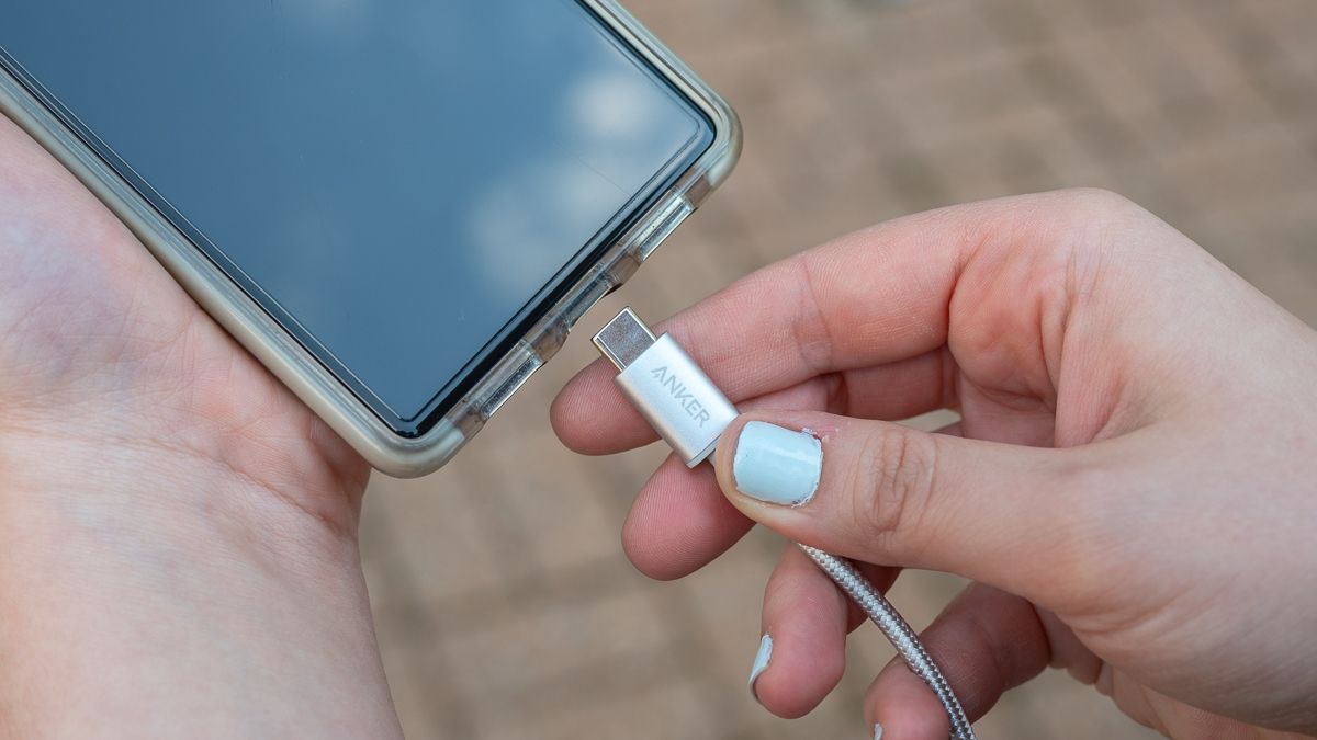 Anker USB-C ケーブルを電話機に接続している人。