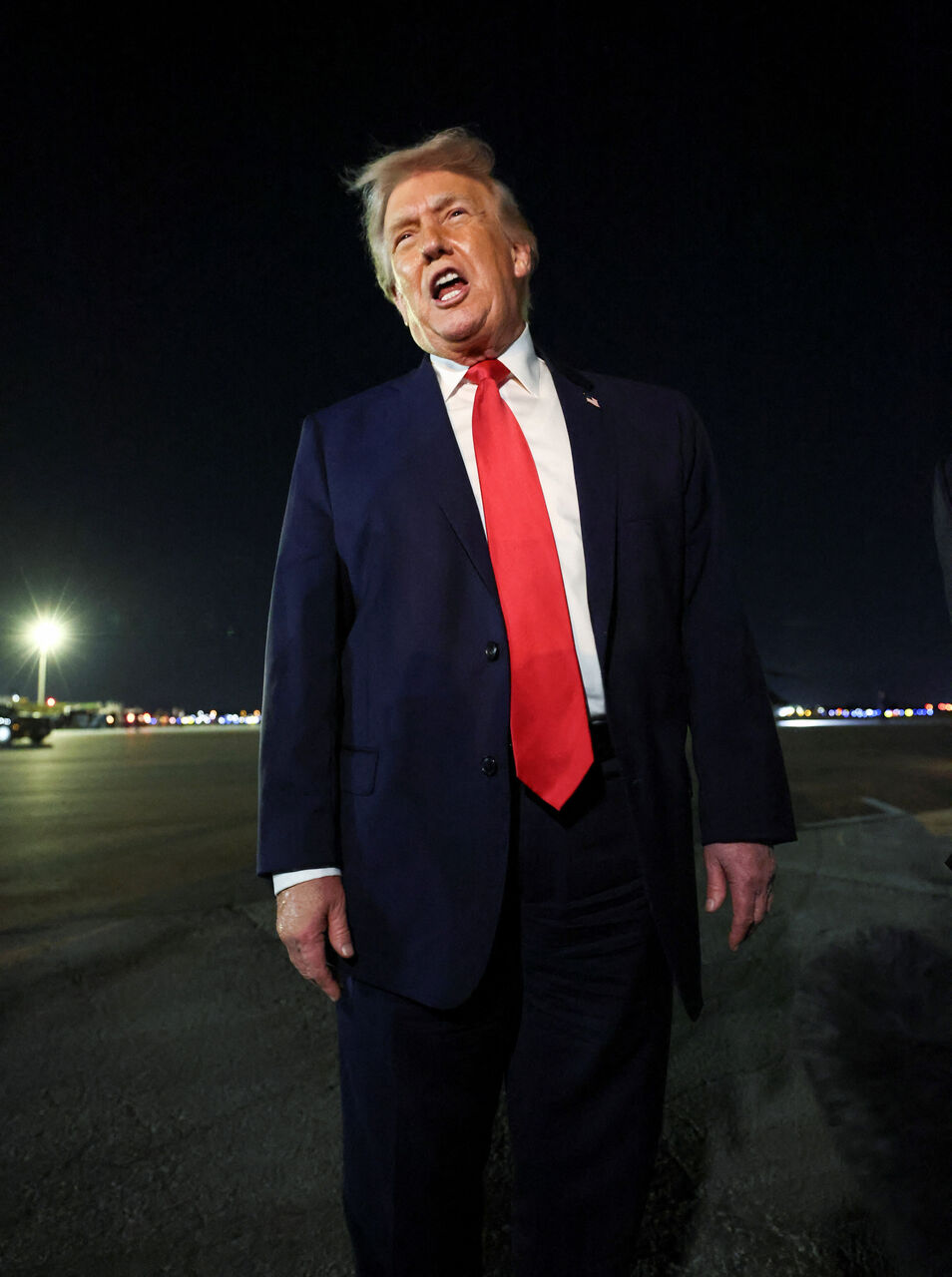 트럼프 대통령이 밤 팜비치 국제공항에서 연설하고 있다.