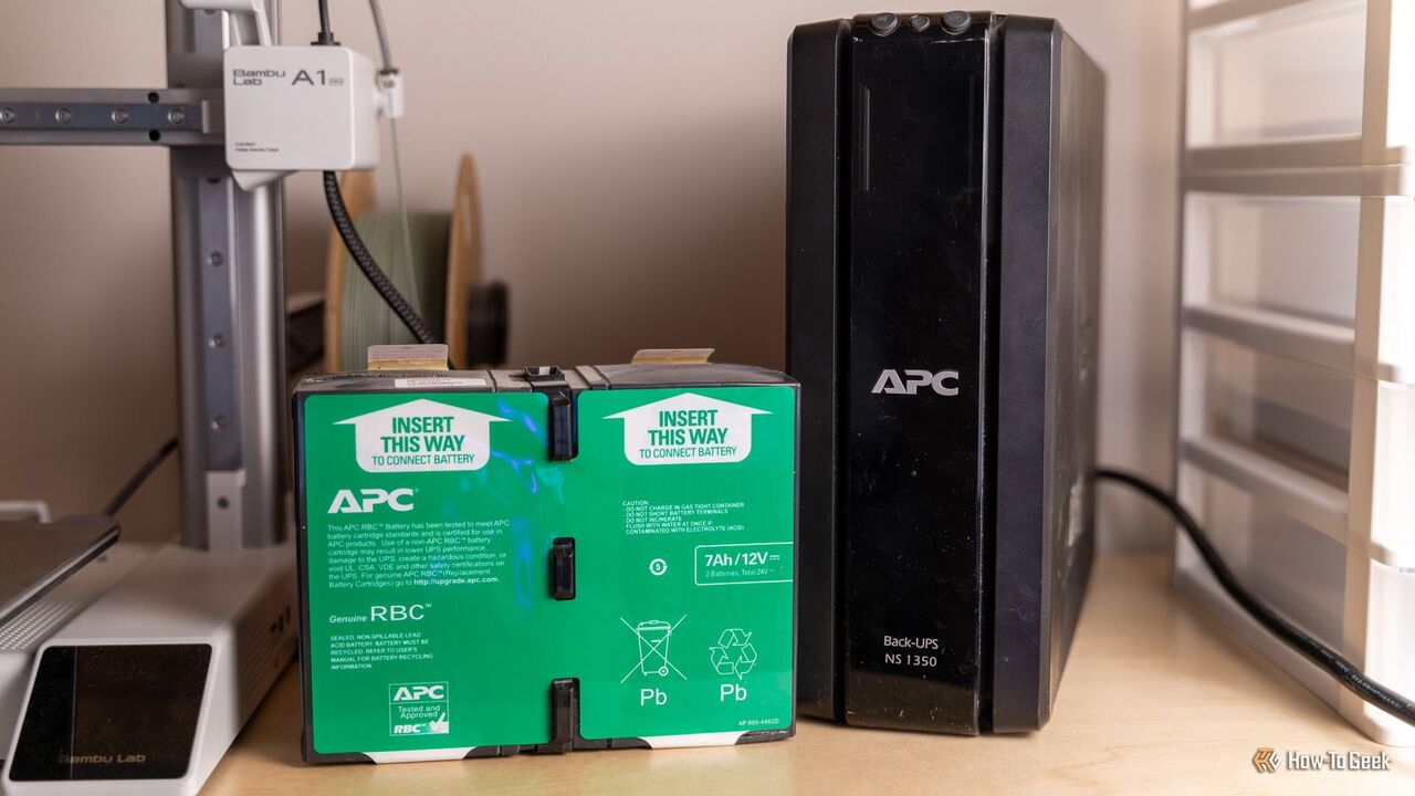 APC BackUPS NS1350 UPS とその隣に古いバッテリーが置かれています。