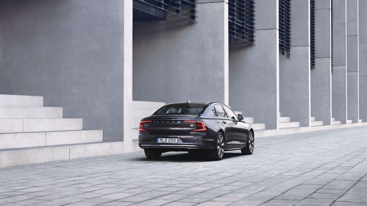 グレーのボルボ S90 リチャージ T8 AWD の静的なリア 3/4 ショット。