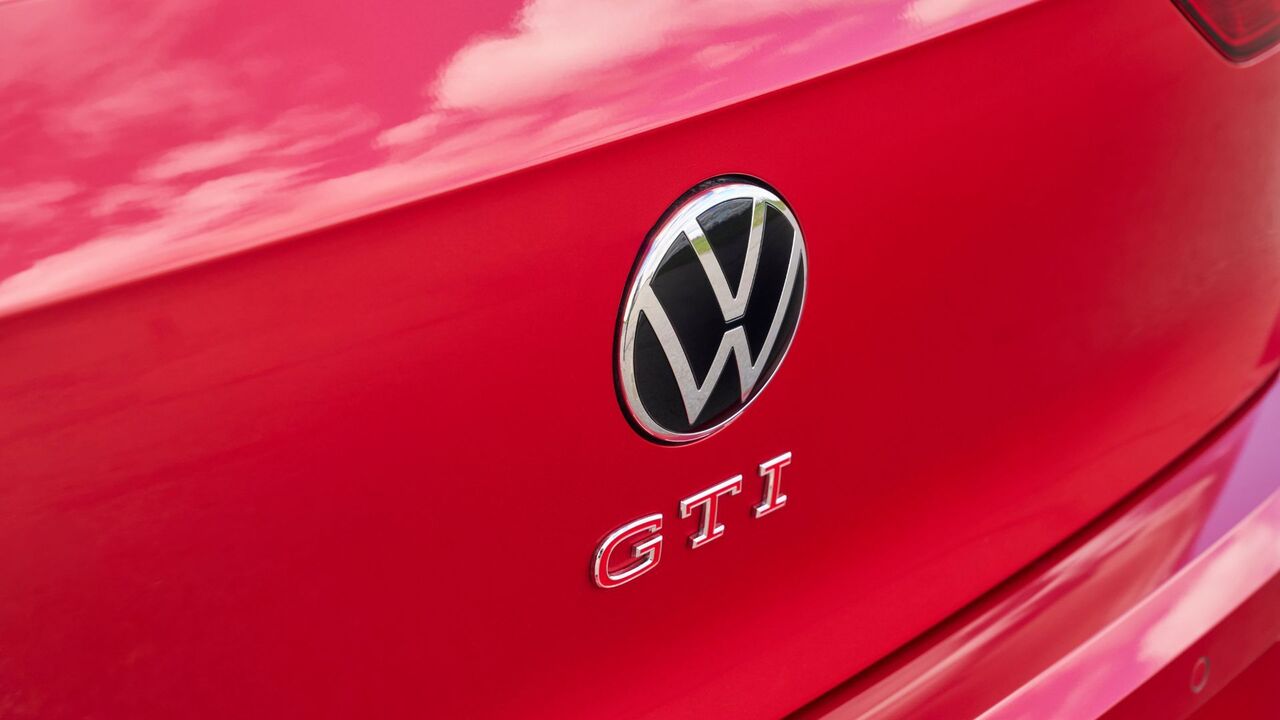 赤い 2025 型フォルクスワーゲン ゴルフ GTI アウトバーンのテールゲートにある GTI バッジのクローズ アップ ショット。