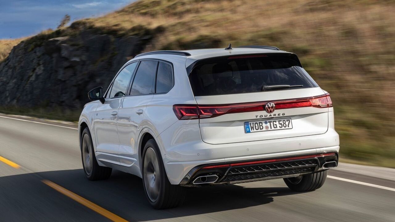 白い 2024 年型フォルクスワーゲン トゥアレグのダイナミックなリア 3/4 ショット。