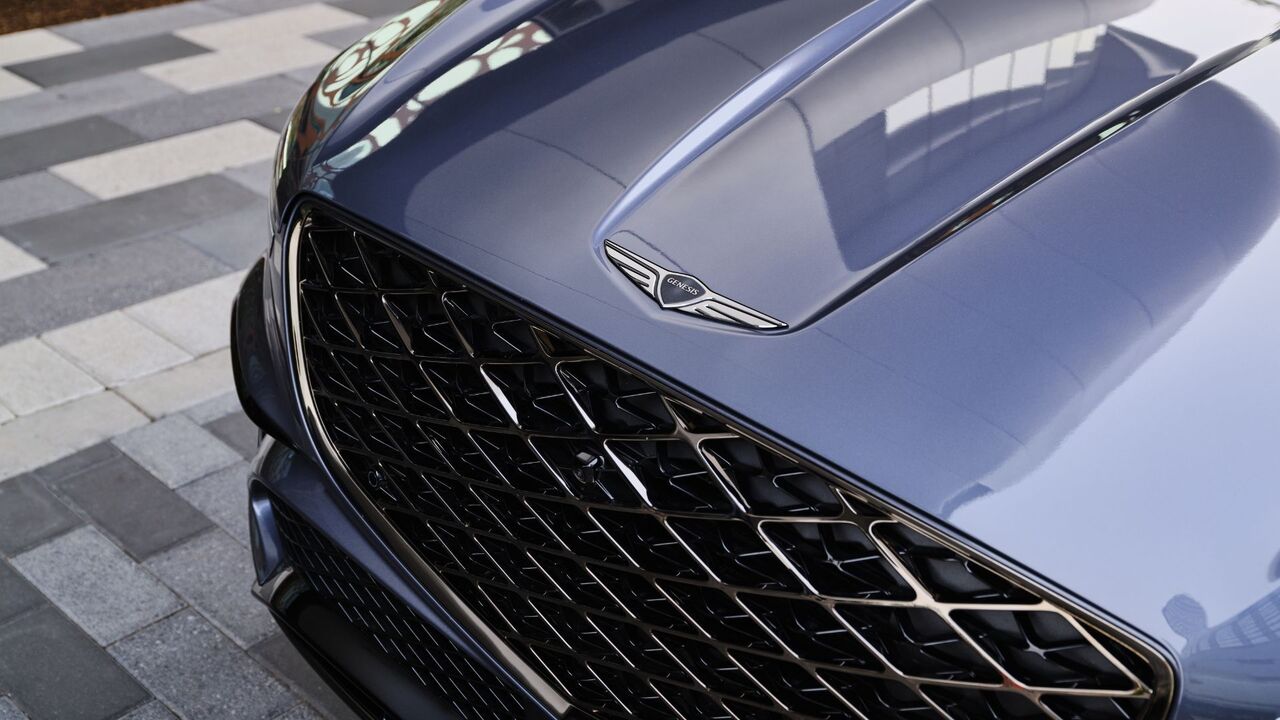 グレーの 2026 ジェネシス GV70 のボンネットのバッジのクローズ アップ ショット。