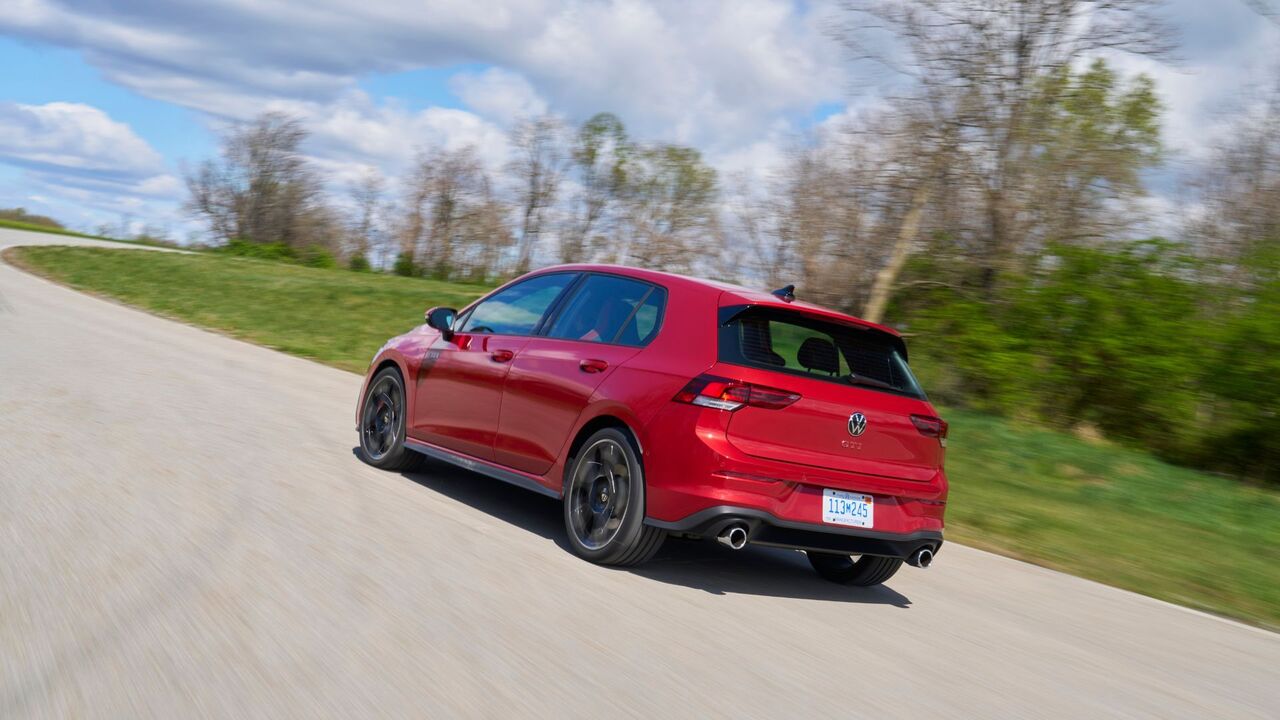 赤い 2025 年型フォルクスワーゲン ゴルフ GTI アウトバーンのダイナミックなリア 3/4 ショット。