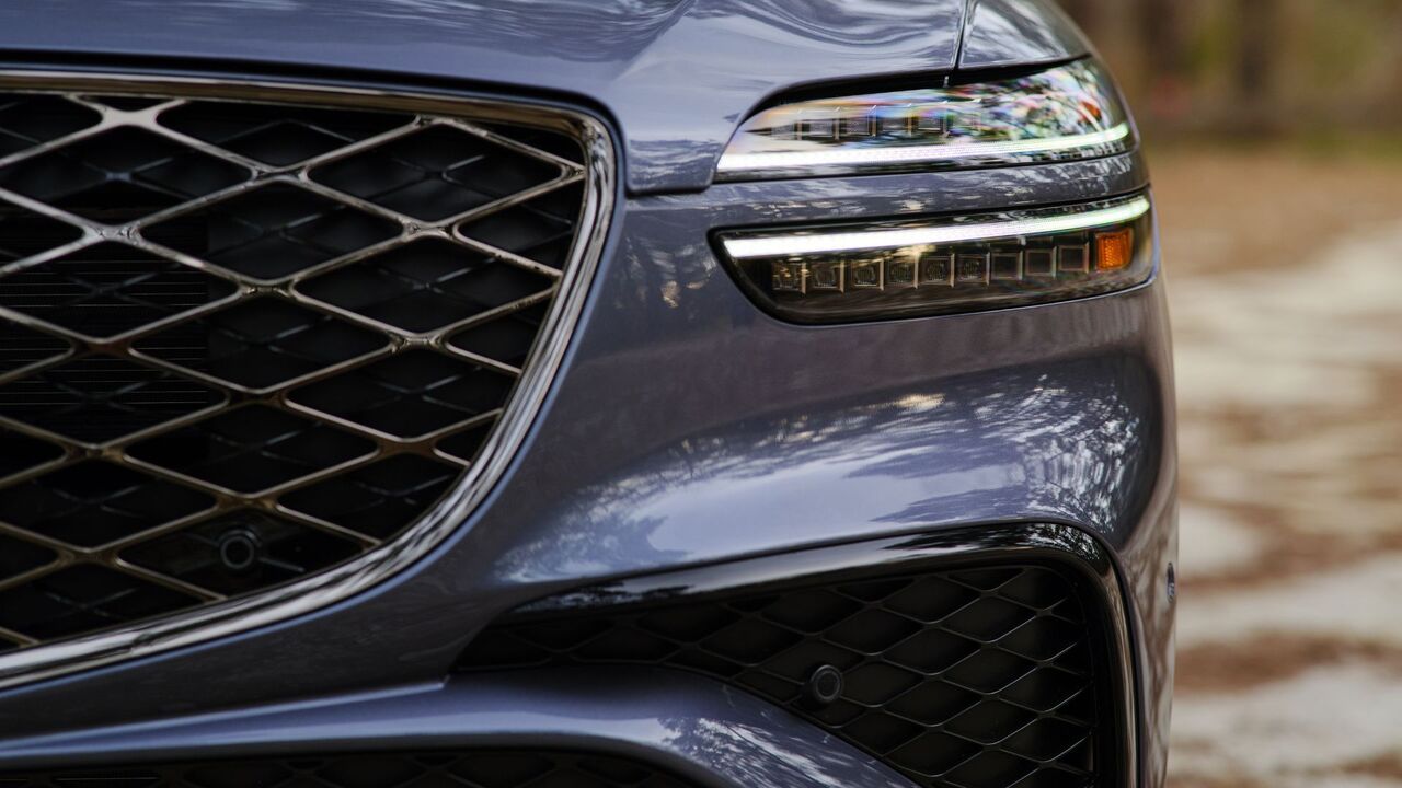 グレーの 2026 ジェネシス GV70 のヘッドライトとグリルのクローズ アップ ショット。