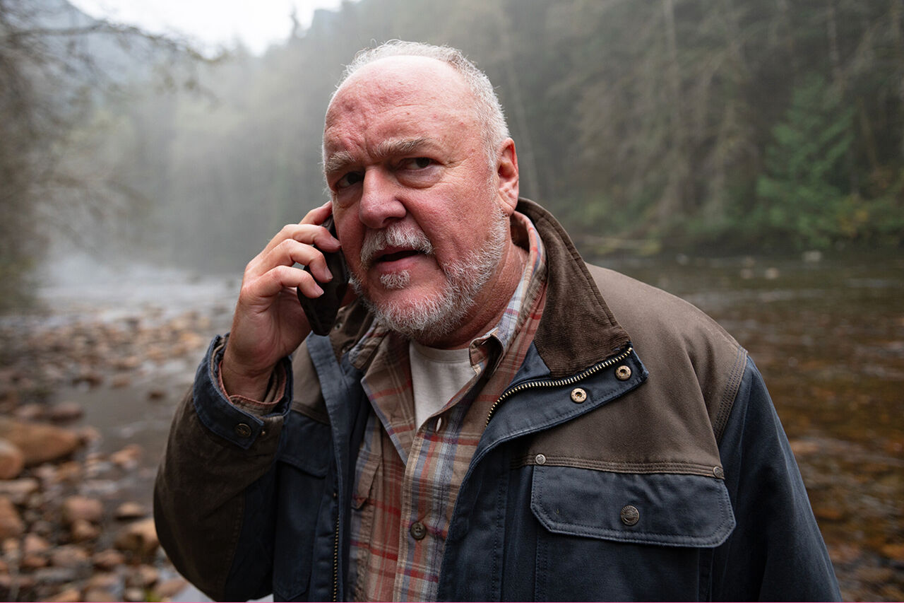 Keaton은 'Tracker'에서 숲 속에 서서 전화기를 귀에 대고 있습니다.