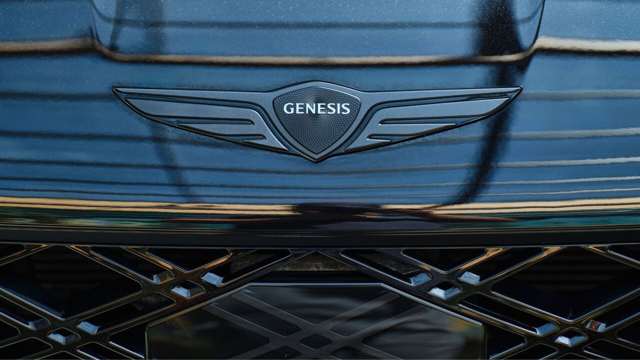黒の 2025 Genesis G80 のボンネットにある「Genesis」バッジのクローズアップショット。
