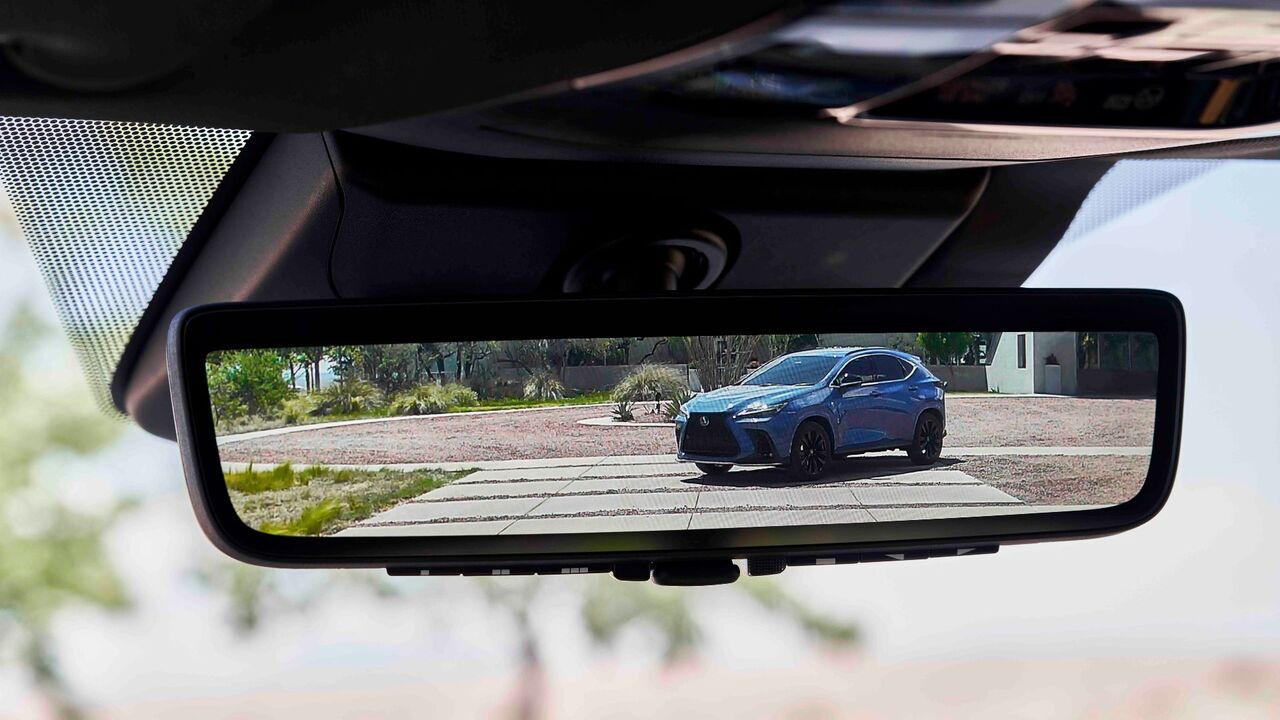 2026年型レクサス NX 350hのバックミラーのクローズアップショット。背景に青い2026年型レクサス NX 350hが表示されています。