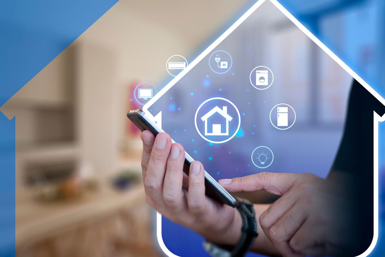 画面上にいくつかのスマート ホーム アイコンが表示されたスマートフォンを持っている手。