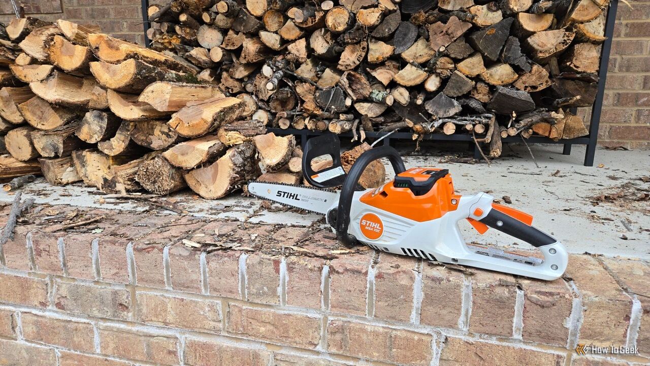 2 つの薪の山の前にある Stihl MSA 70 C チェーンソー。