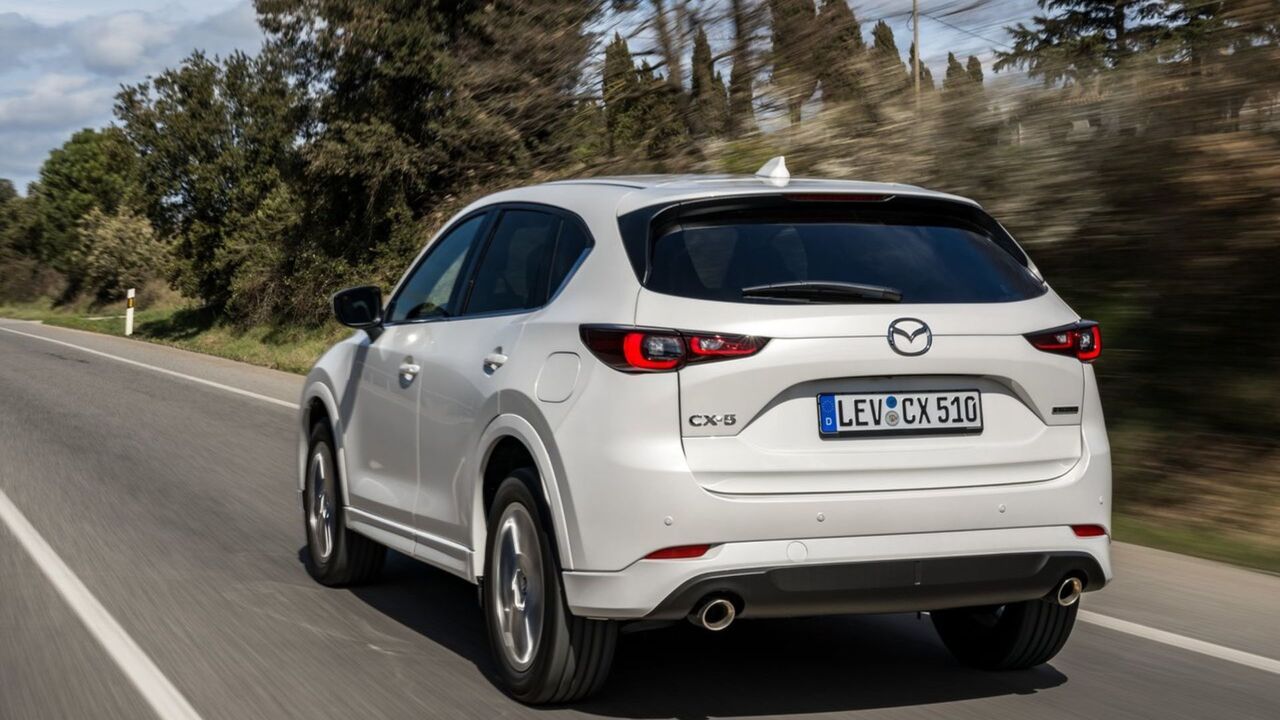 白い 2023 マツダ CX-5 のダイナミックなリア 3/4 ショット。