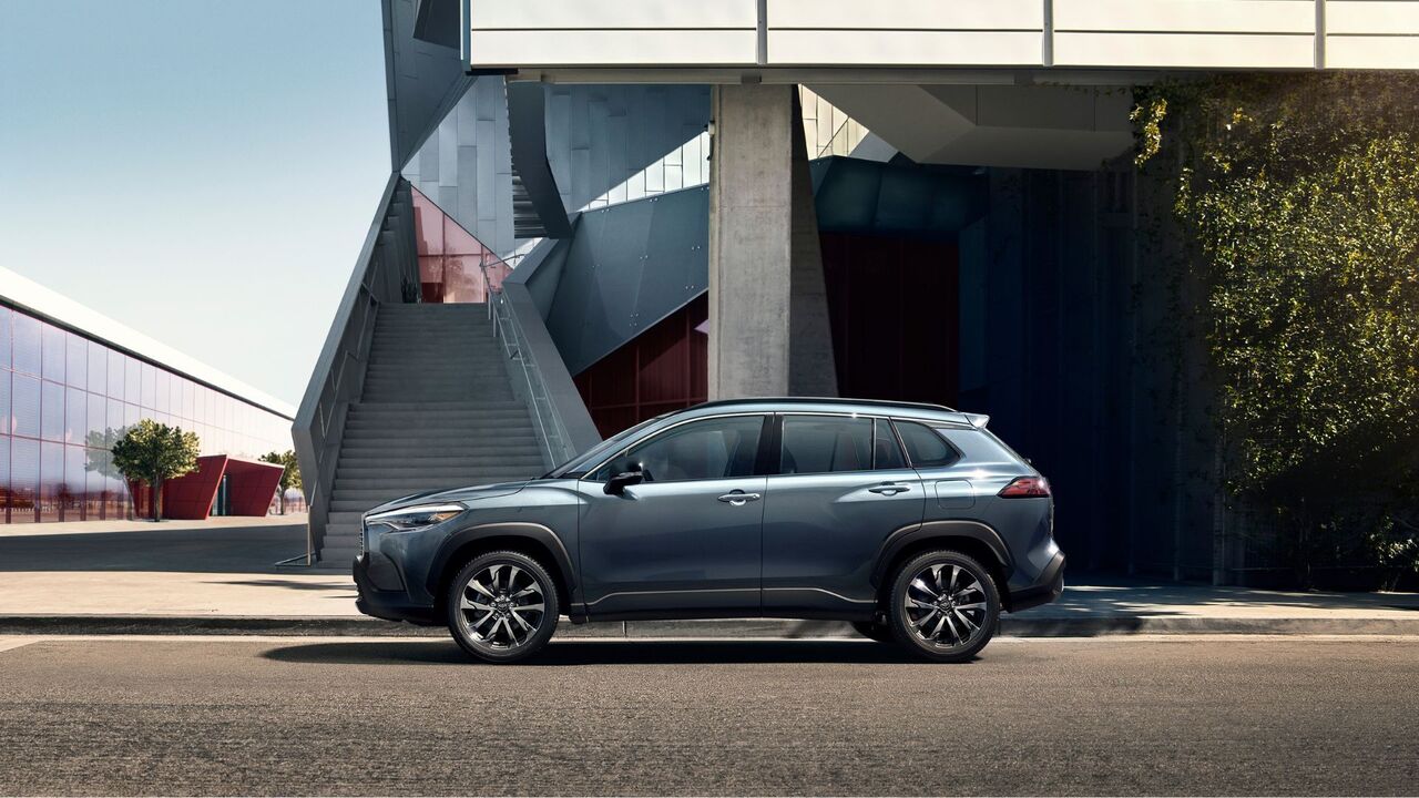 青い 2025 トヨタ カローラ クロス XLE の静的な側面ショット。