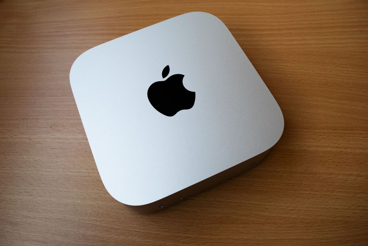 木製のテーブルに置かれた M4 Mac Mini。 