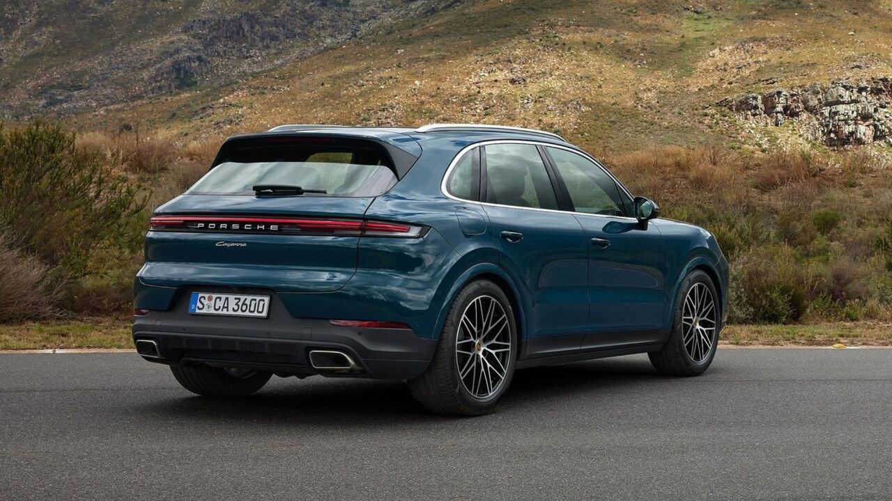 青い 2024 年型ポルシェ カイエンの静的なリア 3/4 ショット。