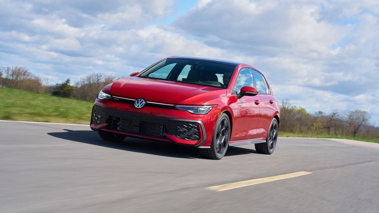 赤い 2025 年型フォルクスワーゲン ゴルフ GTI アウトバーンのダイナミックなフロント 3/4 ショット。