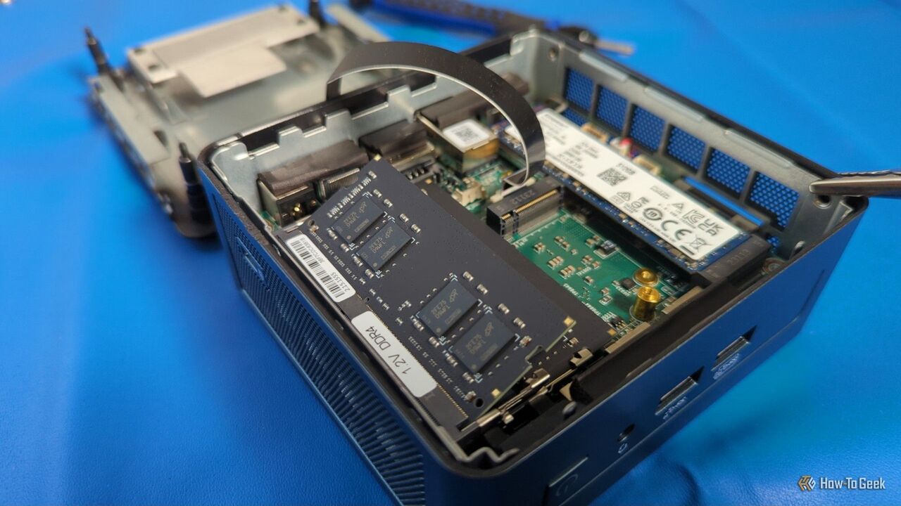 パーツが見える開いたミニ PC、RAM スティックが取り付けられていない状態。-1