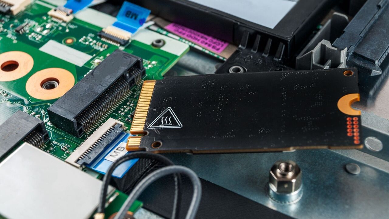 反対側に熱警告ラベルが貼られたノートパソコンの SSD。