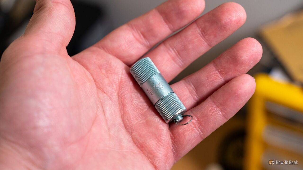 手に持った OLIGHT I1R 2 LED 懐中電灯。