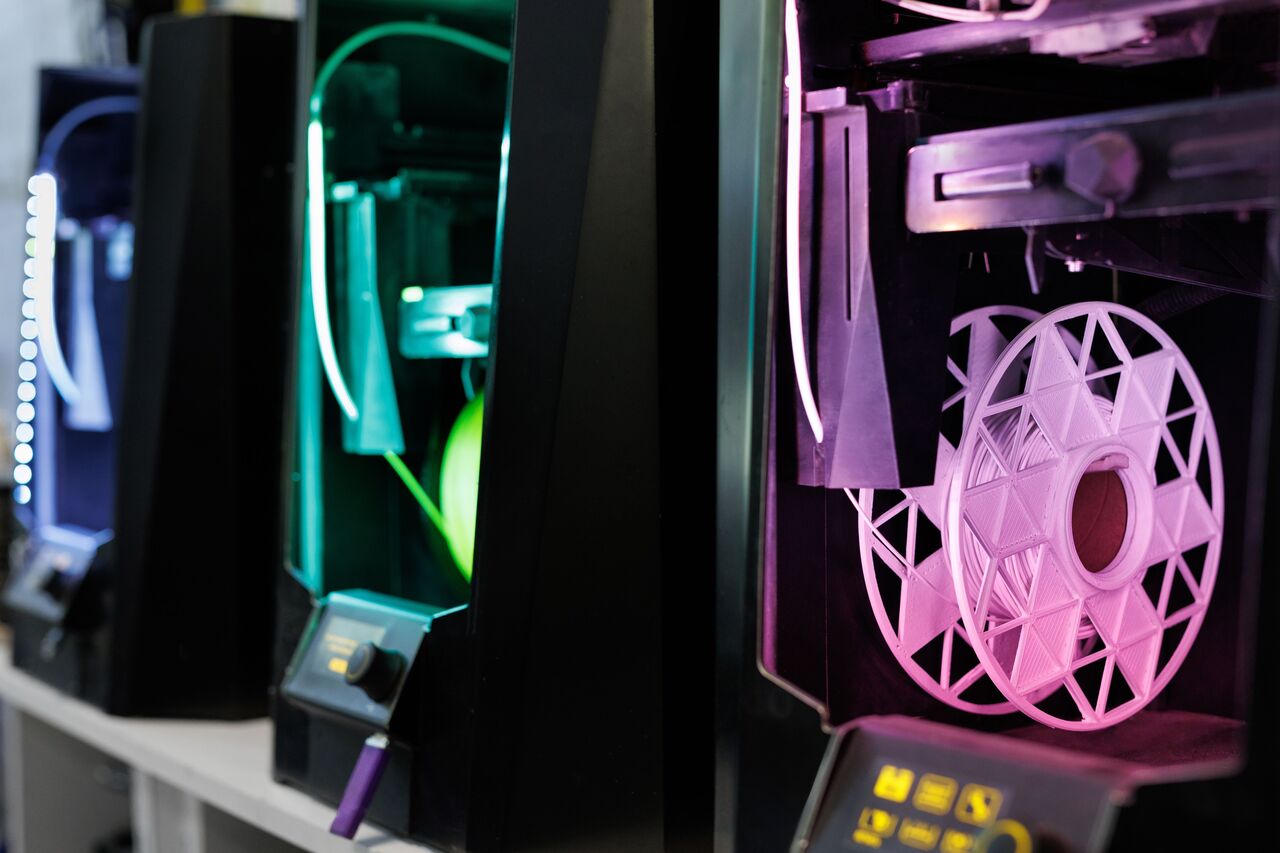 プリンターの側面に取り付けられたスプールを示す 3D プリント ファーム。