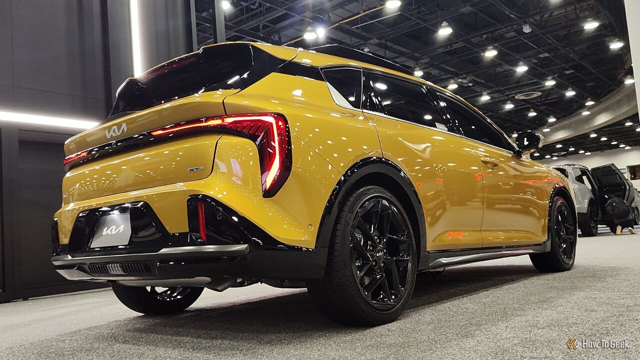 黄色の 2026 Kia K4 ハッチバックの静的なリア 3/4 ショット。