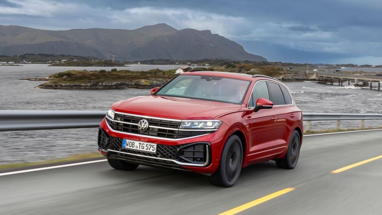 赤い 2024 年型フォルクスワーゲン トゥアレグのダイナミックなフロント 3/4 ショット。