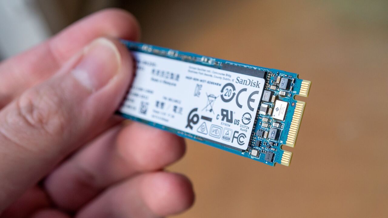 SanDisk M.2 SSD ソリッド ステート ドライブを手に持っています。