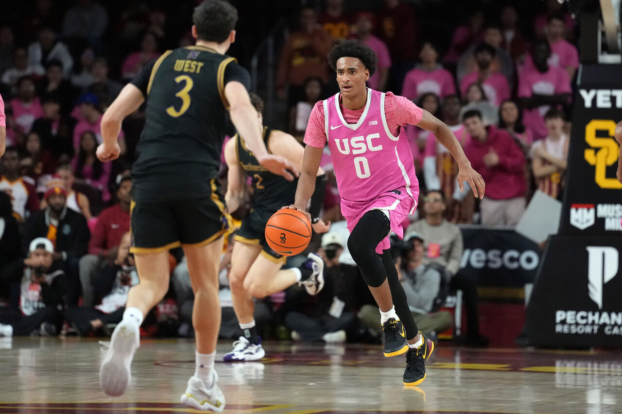 USC가 노스웨스턴에게 패한 동안 알리야 아레나스가 코트 위로 드리블하고 있습니다.
