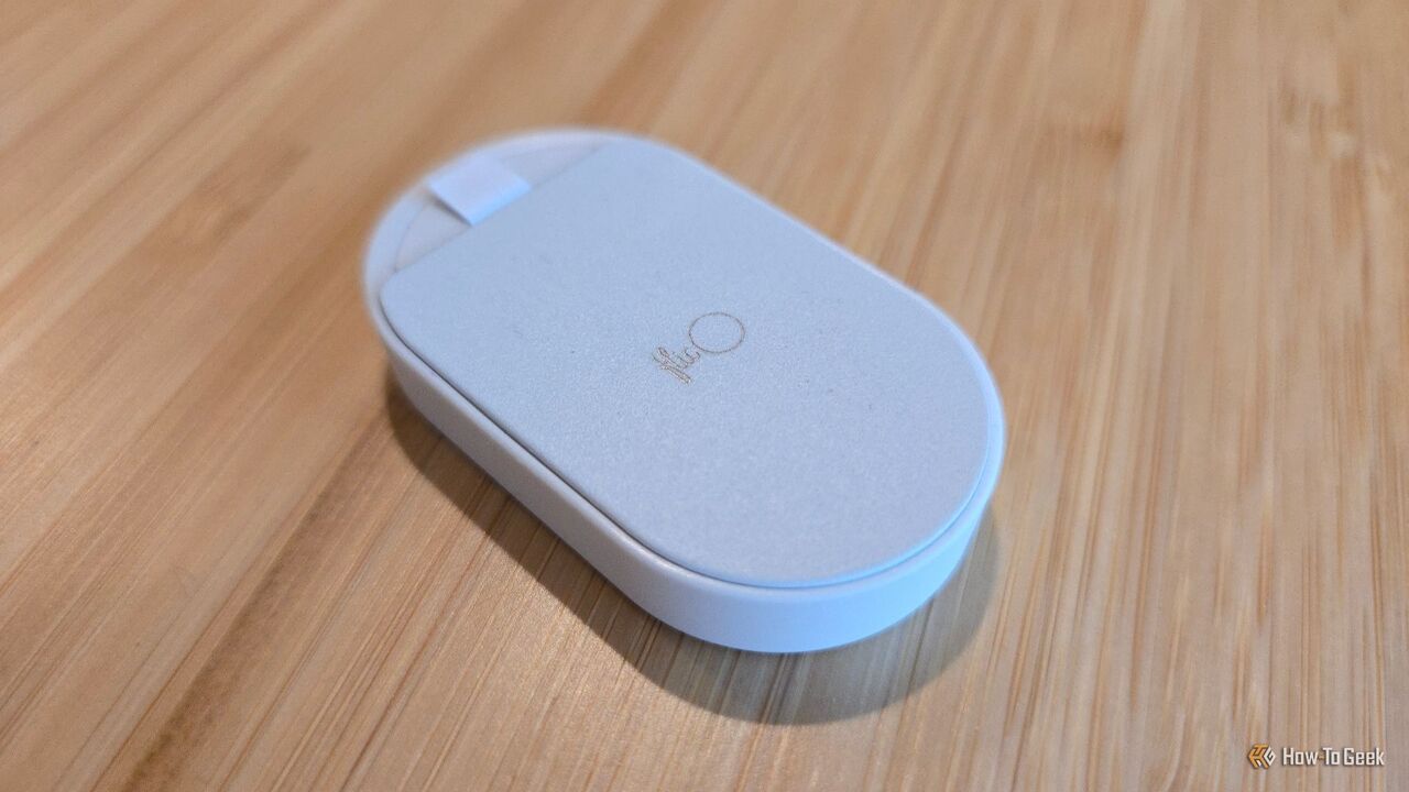 Flic Duo スマート ホーム コントローラーの背面を下にして木の表面に置きます。