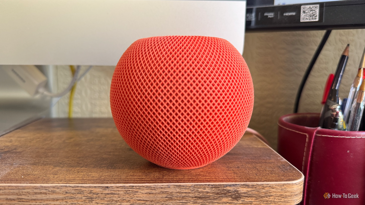 iMac の画面の前にある Apple HomePod mini。
