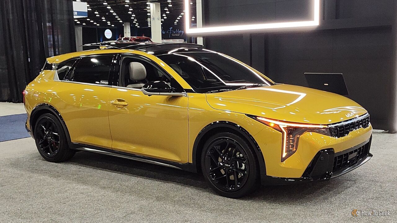 黄色の 2026 Kia K4 ハッチバックの静的なフロント 3/4 ショット。