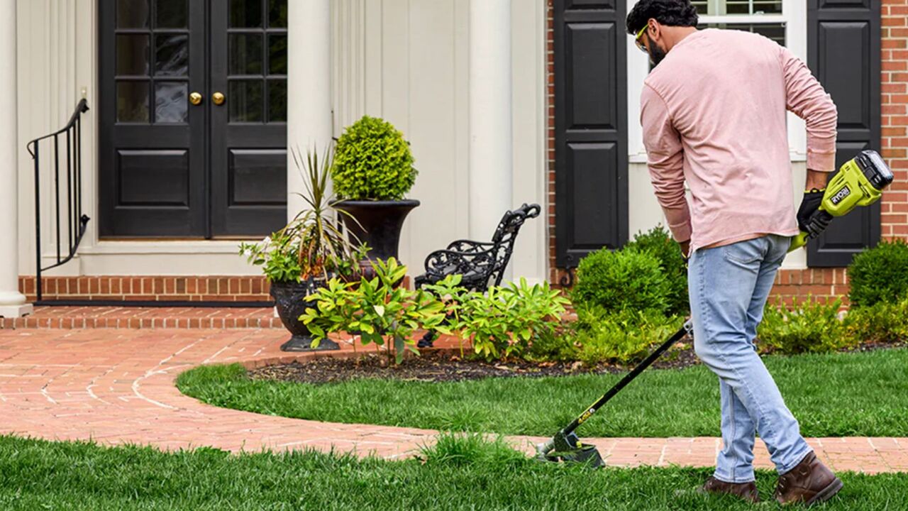 リョービの新しいストリングトリマーを使用する男性