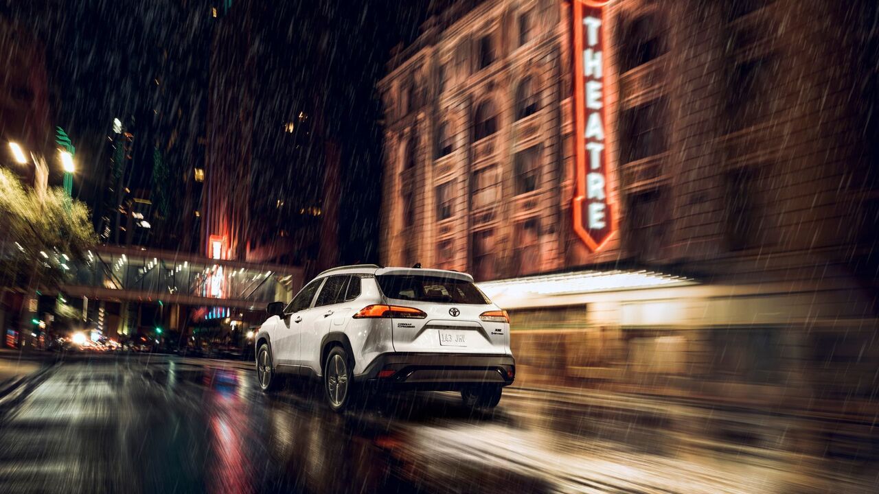 白い 2025 トヨタ カローラ クロス ハイブリッド XSE のダイナミックなリア 3/4 ショット。