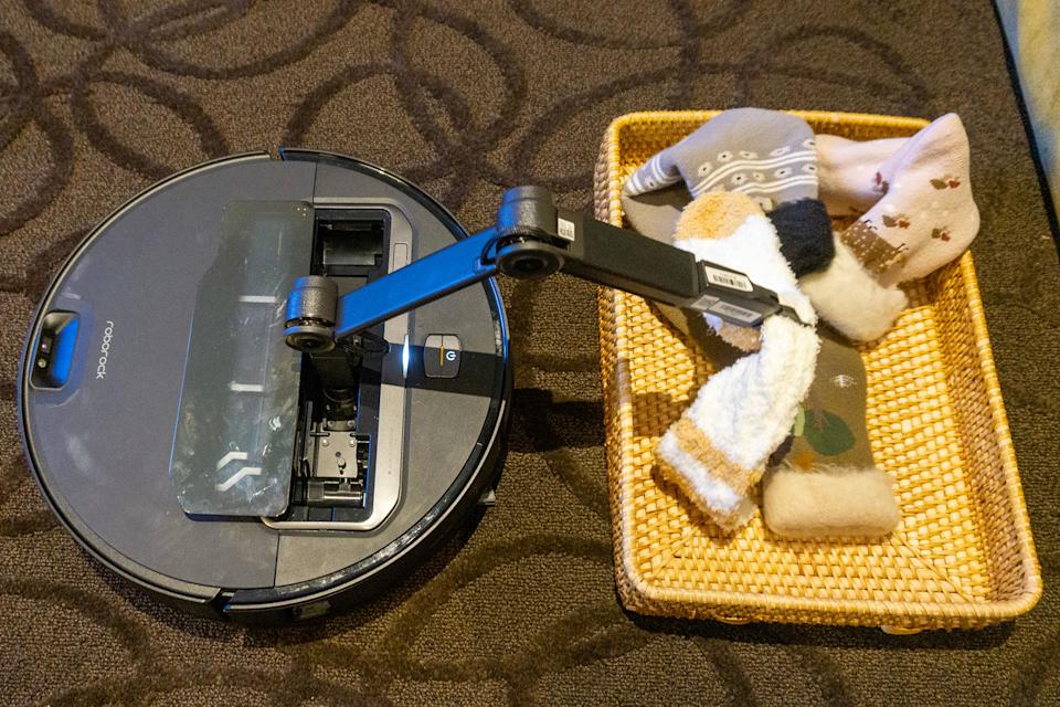 Roborock Saros Z70은 로봇 팔을 사용하여 양말 몇 개를 바구니에 넣습니다.