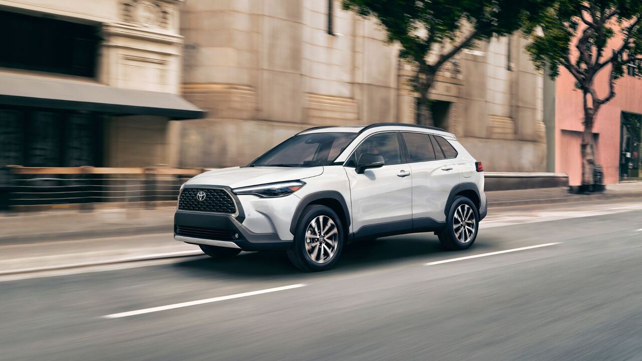 白い 2025 トヨタ カローラ クロス ハイブリッド XSE のダイナミックなフロント 3/4 ショット。