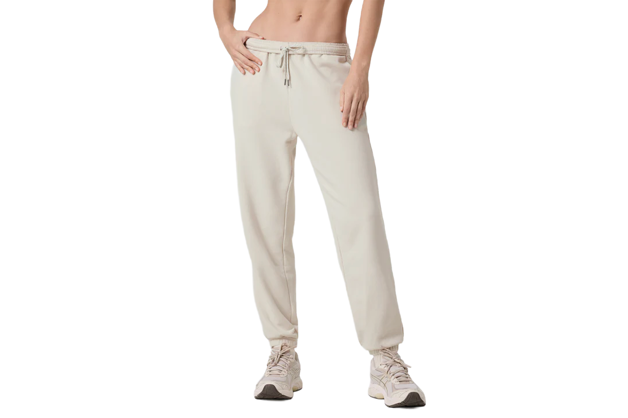 밝은 베이지색 조깅 팬츠에 흰색 운동화를 신은 사람.