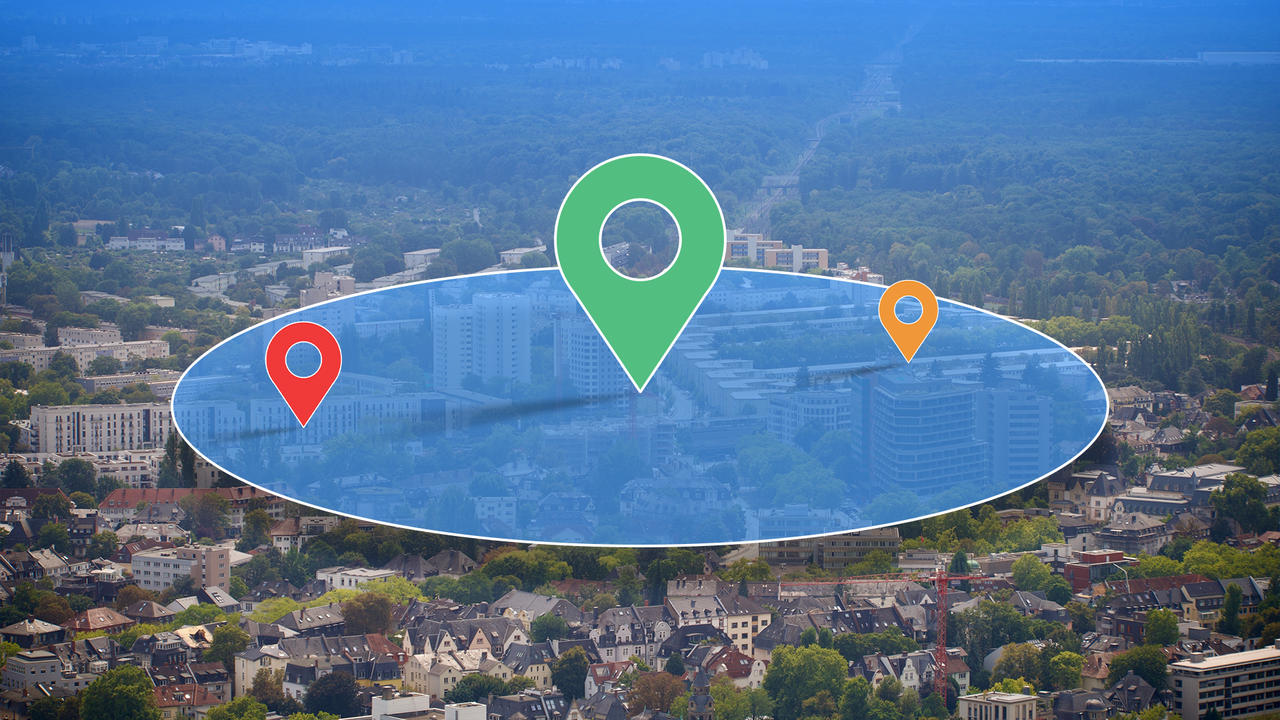大きな地図の位置ピンと青い円形ゾーンのオーバーレイを備えた都市の航空写真。