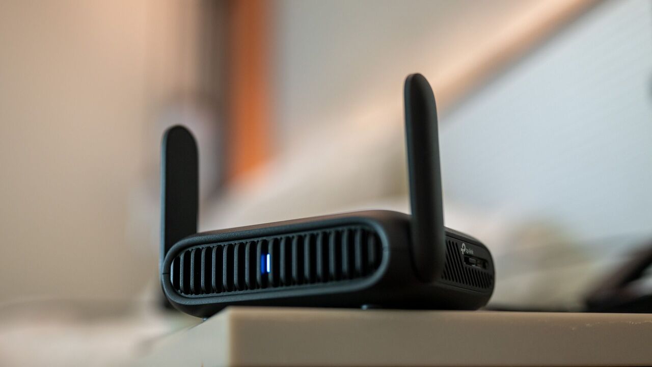 ホテルの部屋のテーブルの上に置かれている TP-Link BE3600 Wi-Fi トラベル ルーター。