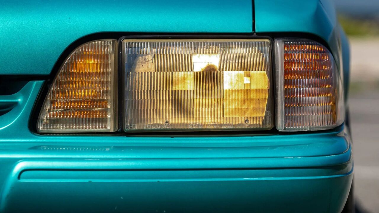 青い 1993 フォード マスタング LX 5.0 のヘッドライトのクローズ アップ ショット。