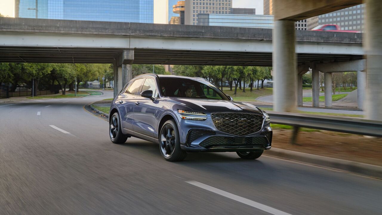 グレーの 2026 Genesis GV70 のダイナミックなフロント 3/4 ショット。