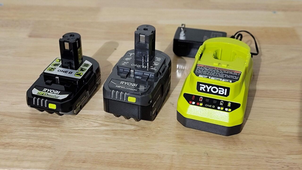 作業台に置かれたリョービのバッテリーと充電器。 