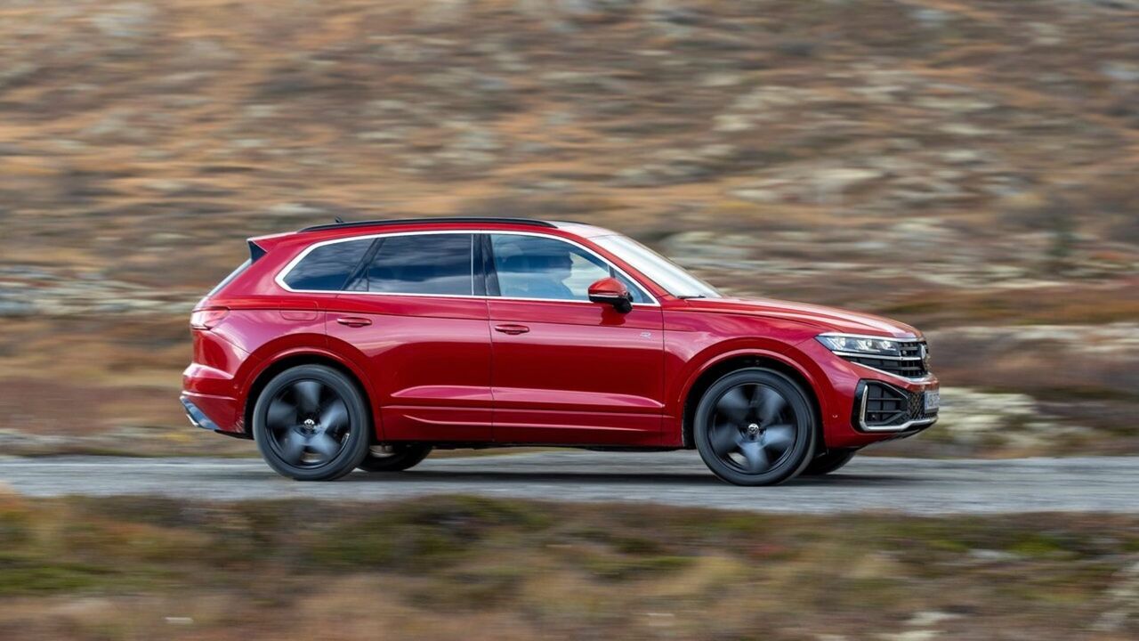 赤い 2024 年型フォルクスワーゲン トゥアレグのダイナミックな側面ショット。