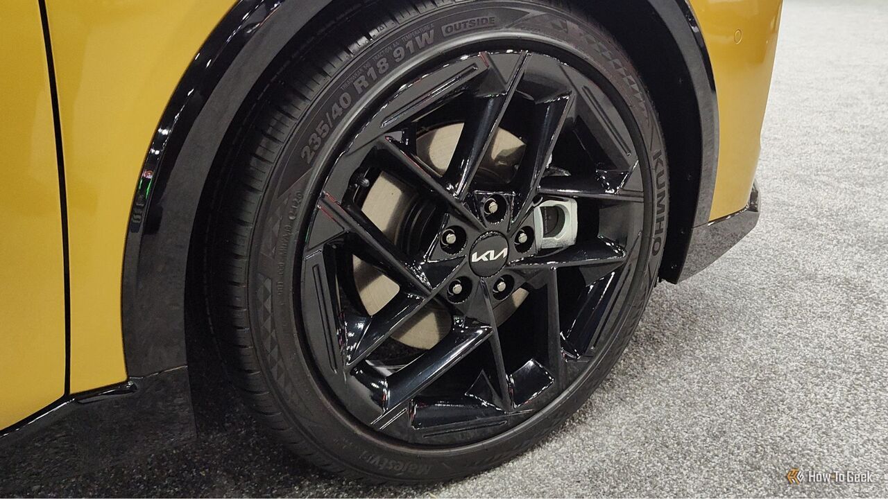 黄色の 2026 Kia K4 ハッチバックの黒い合金ホイールのクローズ アップ ショット。