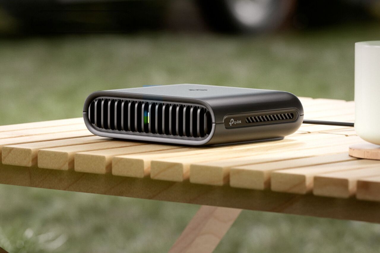 屋外のテーブルの上にある小さな黒いルーター