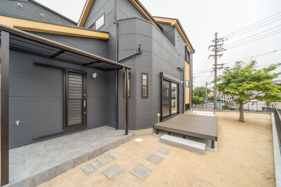 ウッドデッキの奥には、タイルテラス。ユニソンの「バレリア」という床材を、飛び石に見立てて施工しています