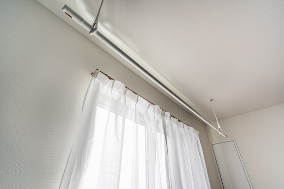 寝室天井には天井付竿掛け、NASTAの「エアフープ」と「ランドリーポール」、室内物干しを設置。